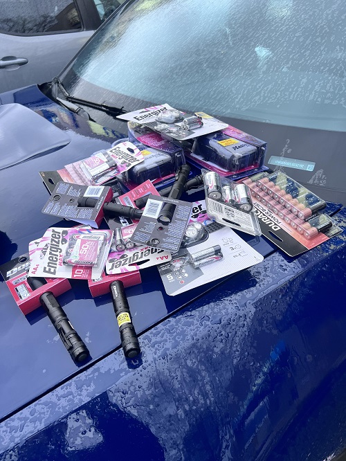 Photo de paquets de piles et de lampes de poche sur le capot d'un véhicule