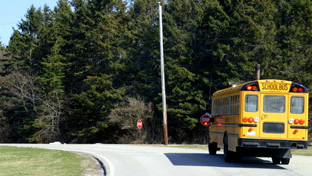 photo of a school bus with its lights on and stop sign extended