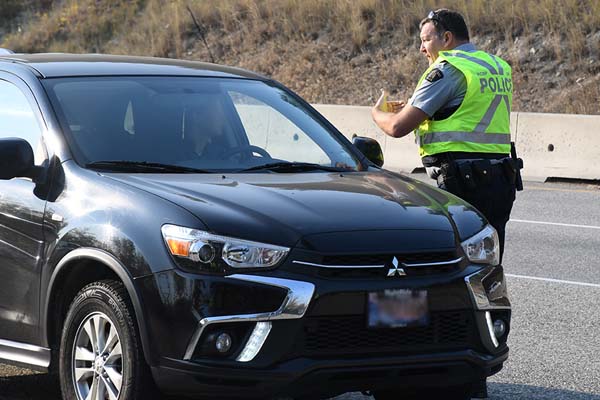 Officier parlant avec le chauffeur dans une voiture