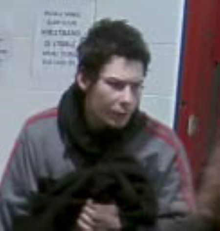 Suspect face: a forward facing head and shoulders photo of a man with dark hair, in a grey jacket with red stripes.