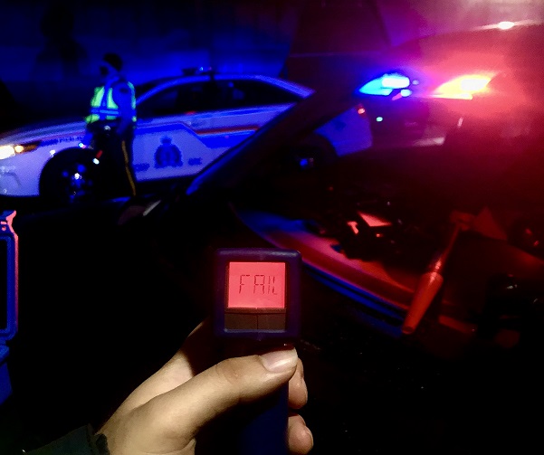 Officer holding an ASD device while it displays a fail reading.