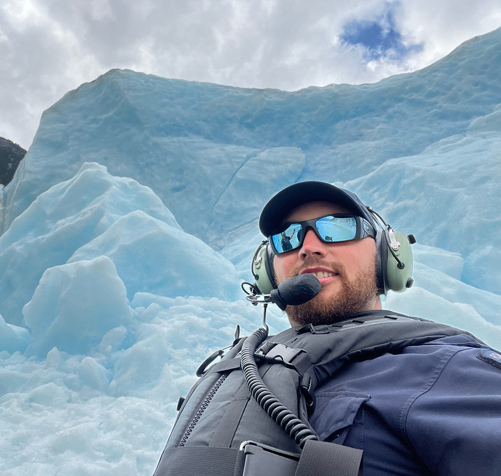Photo of officer in front of a glacier